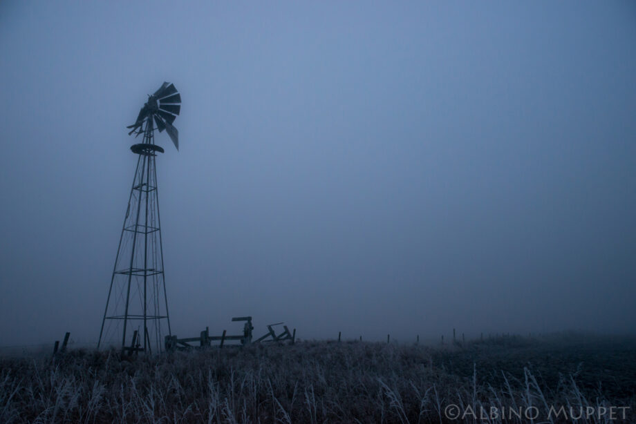 Old windmill in field with thick fog and frost, Alberta landscape